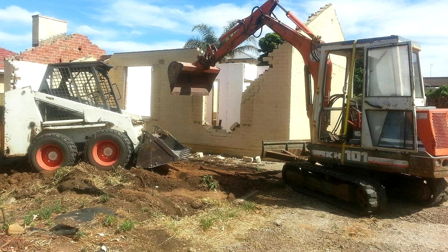 Mr Earthworx excavator and bobcat demolishing a brick house on a southern Adelaide job site